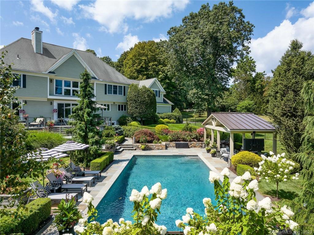 a front view of a house with a yard swimming pool and outdoor seating