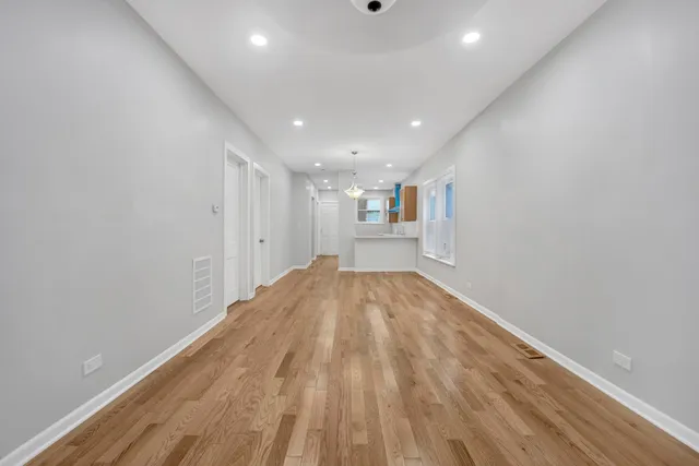 a view of empty room with wooden floor