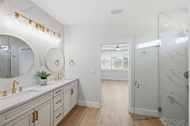 an empty room with wooden floor and ceiling fan