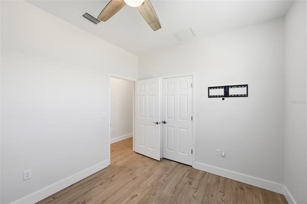 17029 Hampton Falls Terrace Lakewood Ranch, FL 34202 - Photo 32 of 56 an empty room with wooden floor and ceiling fan
