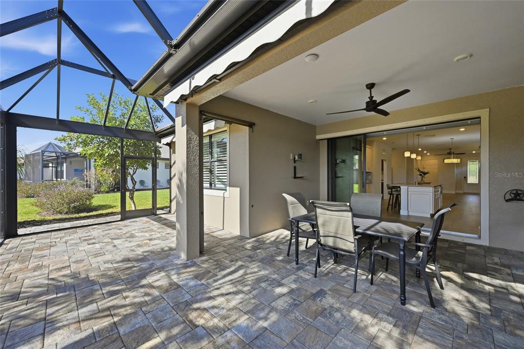 17029 Hampton Falls Terrace Lakewood Ranch, FL 34202 - Photo 37 of 56 a view of a patio with table and chairs next to a yard