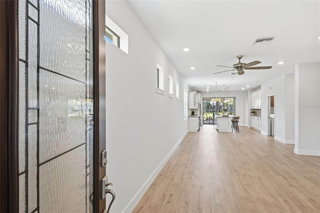 17029 Hampton Falls Terrace Lakewood Ranch, FL 34202 - Photo 8 of 56 a view of a living room with hardwood floor and a ceiling fan