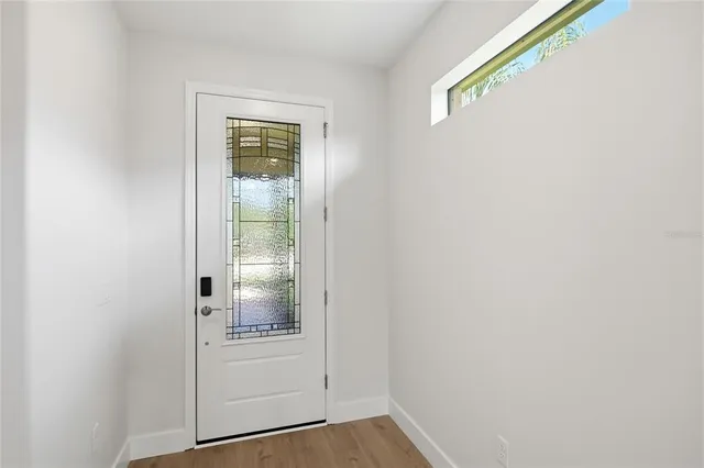 a view of empty room with wooden floor and window