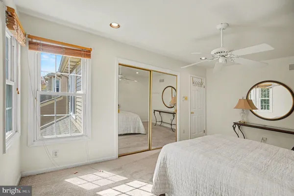 a bedroom with a bed a mirror and a window