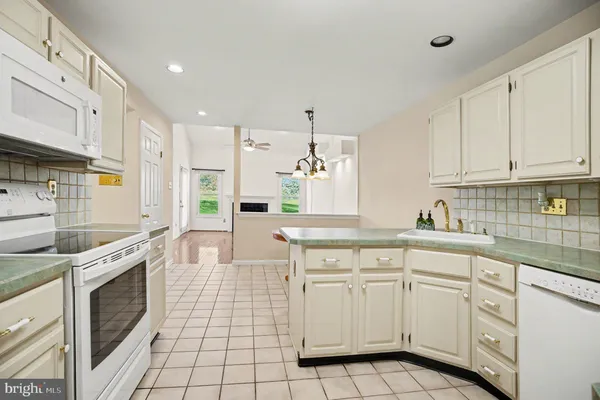 a kitchen with white cabinets appliances and sink