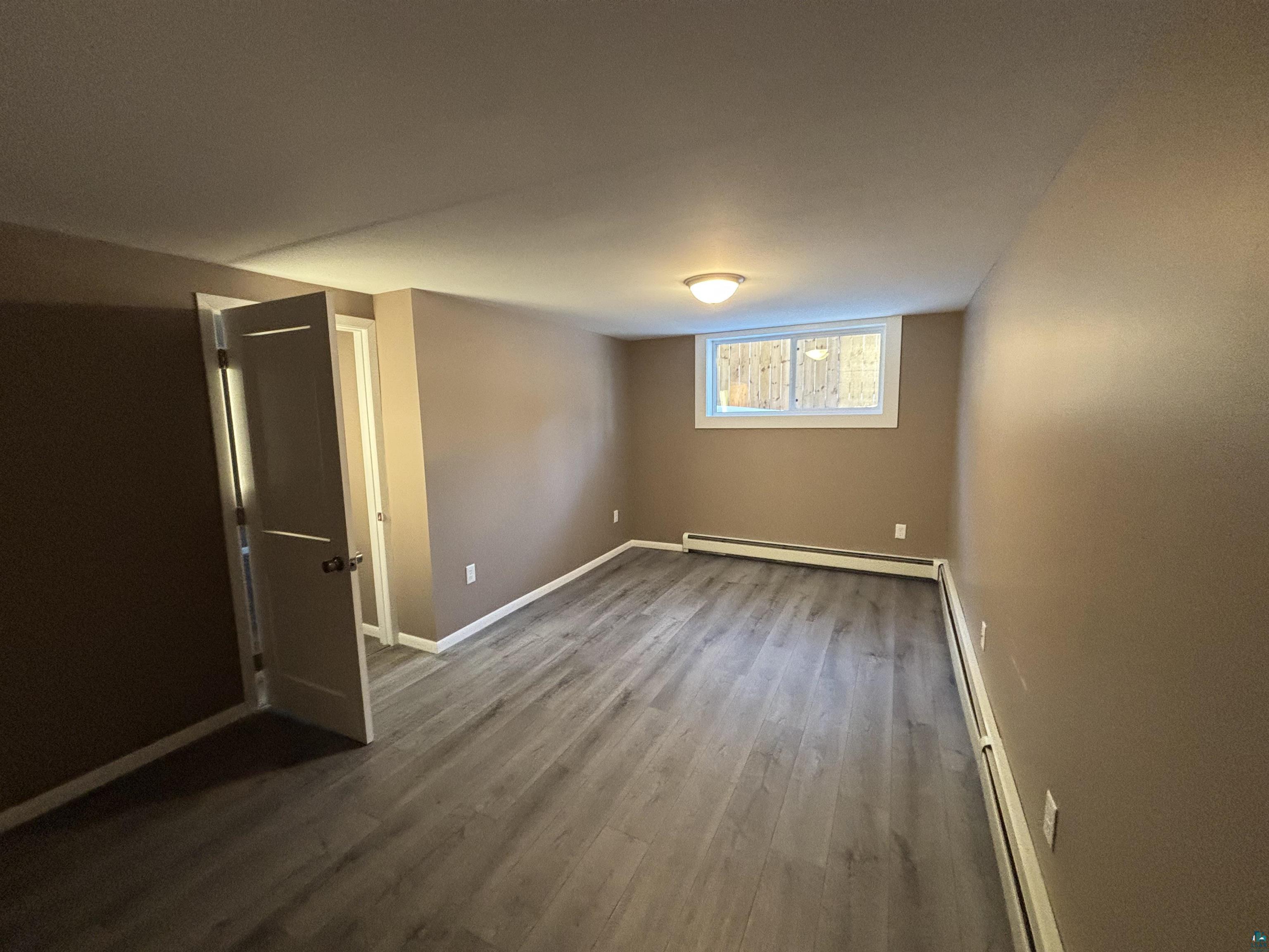 4919 Oakley Street Duluth, MN 55804 - Photo 19 of 20 Below grade area with baseboard heating and dark wood-type flooring
