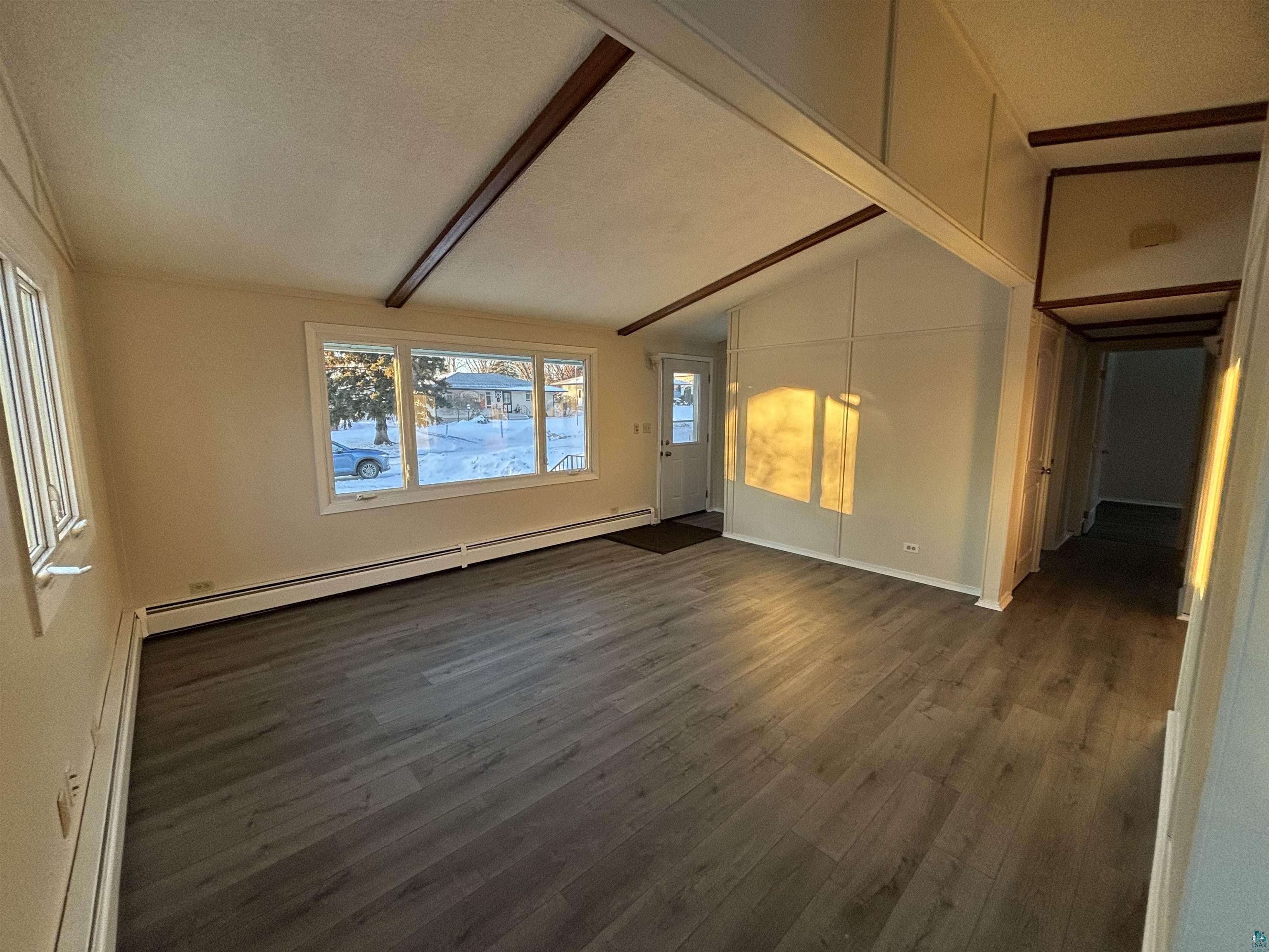 4919 Oakley Street Duluth, MN 55804 - Photo 5 of 20 Unfurnished living room with a baseboard radiator, dark wood-type flooring, and a textured ceiling