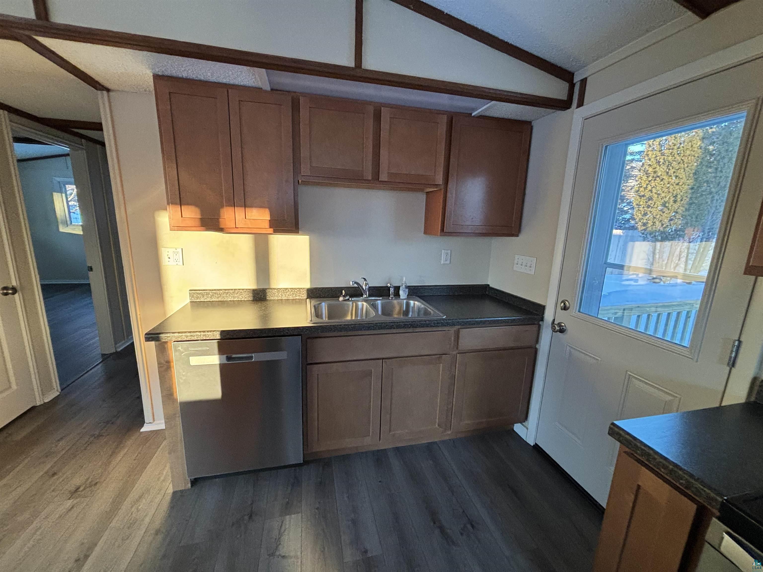 4919 Oakley Street Duluth, MN 55804 - Photo 9 of 20 Kitchen featuring dishwasher, dark countertops, dark wood finished floors, lofted ceiling, and a textured ceiling