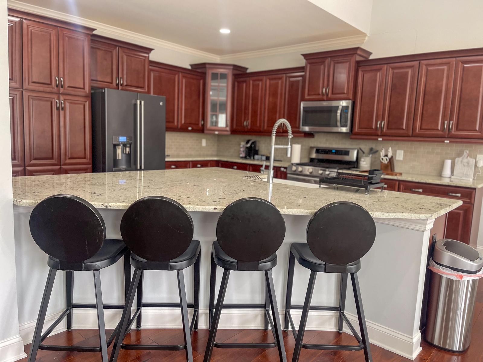 7152 Triple Crown Lane Fairview, TN 37062 - Photo 8 of 10 a kitchen with granite countertop a counter space chairs stainless steel appliances and cabinets