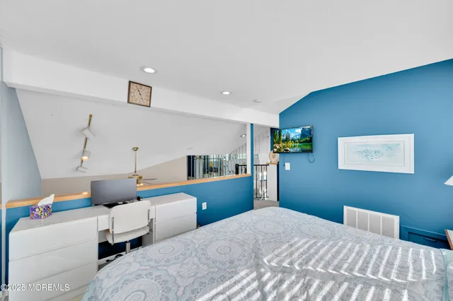 a bedroom with a bed and large windows