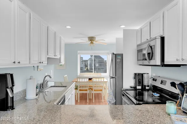 a kitchen with stainless steel appliances granite countertop a refrigerator stove oven and a sink