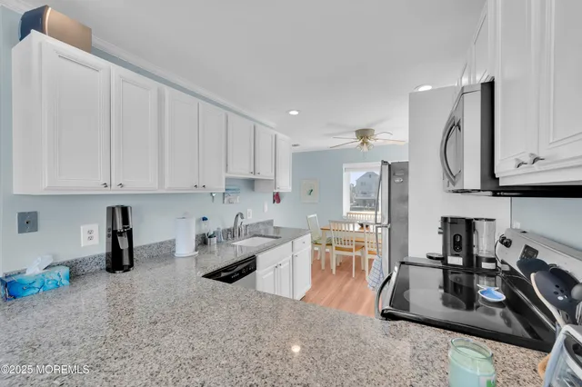 a kitchen with stainless steel appliances granite countertop a sink refrigerator and microwave
