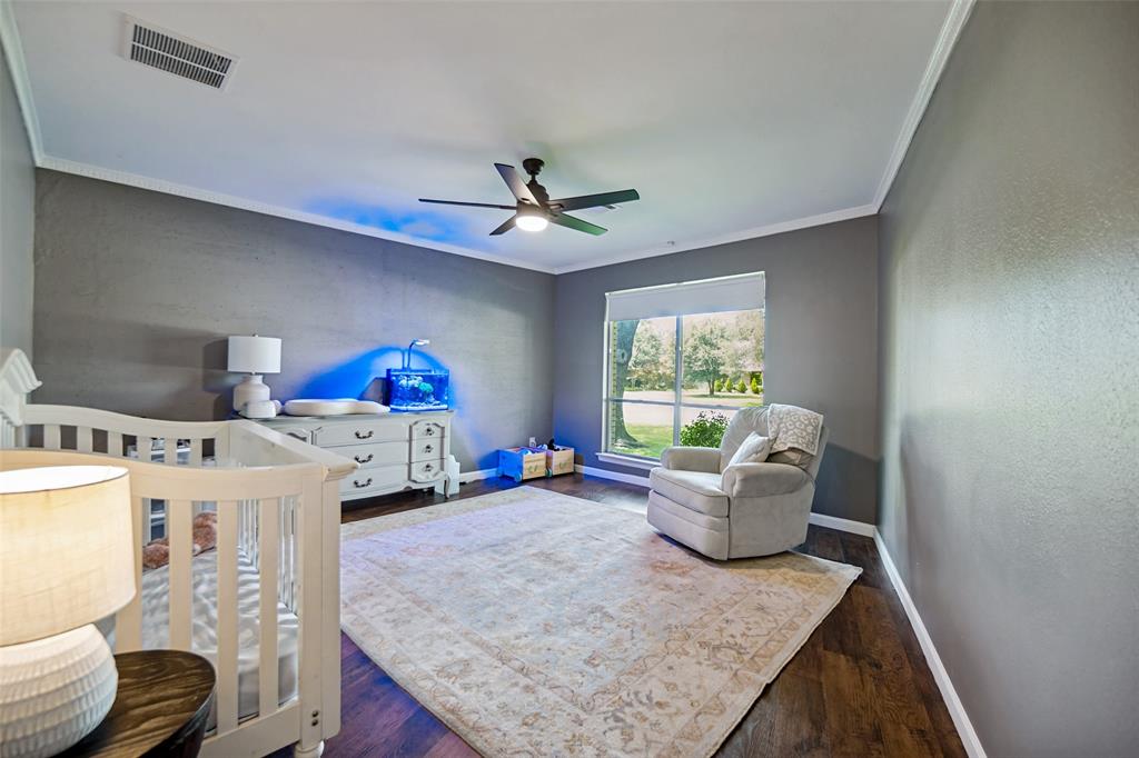 4614 Ridgeside Drive Dallas, TX 75244 - Photo 18 of 30 Warm wood-finish flooring, a large window, and crown molding enhance this room