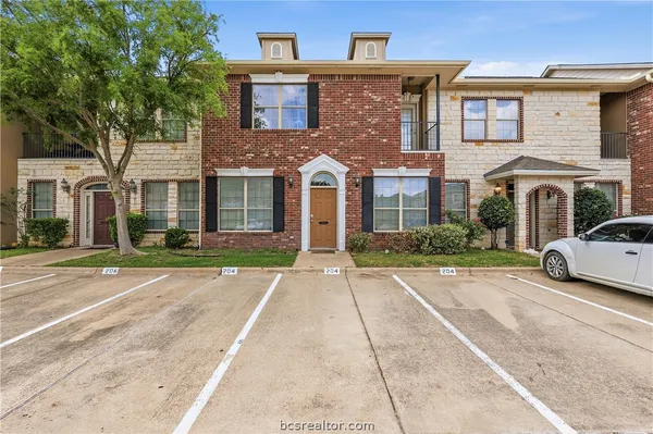 front view of a brick house with a yard