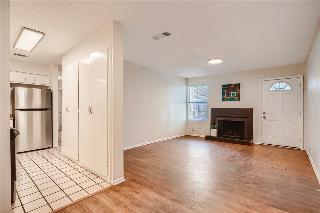 2712 Parker Lane, Unit A Austin, TX 78741 - Photo 2 of 13 a view of an empty room with wooden floor and a fireplace