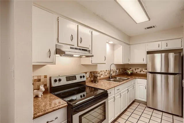a kitchen with cabinets stainless steel appliances and wooden floor