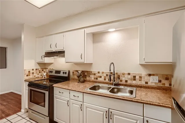 a kitchen with kitchen island granite countertop white cabinets and white appliances