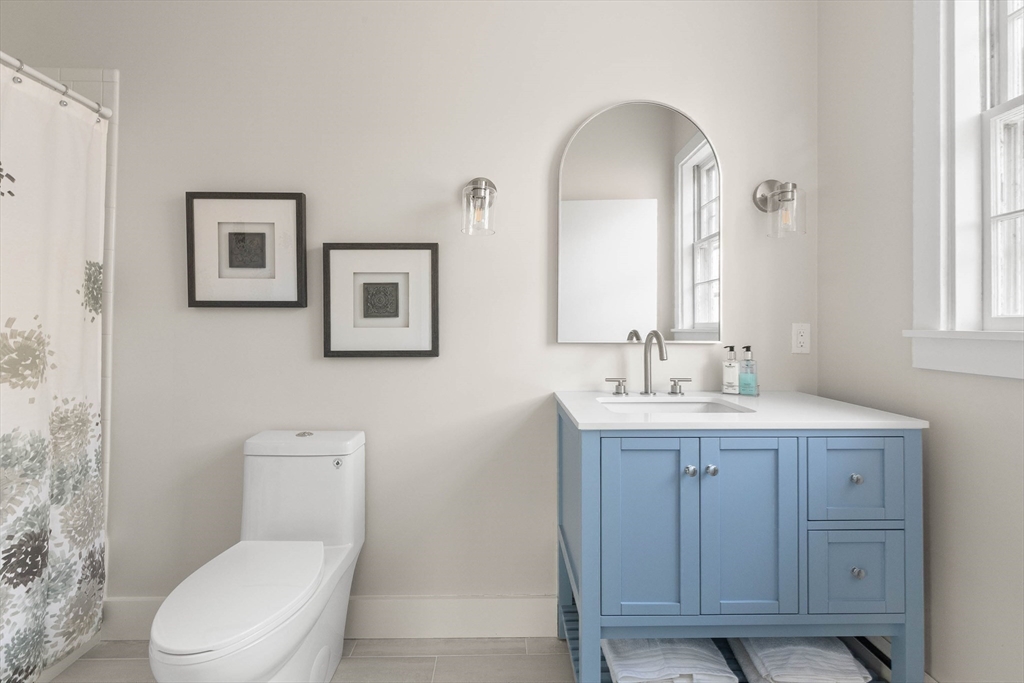 250 Cutler Road Hamilton, MA 01982 - Photo 24 of 34 a bathroom with a toilet a sink a mirror and a window
