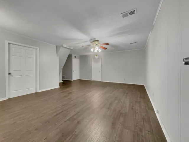 a view of an empty room with wooden floor