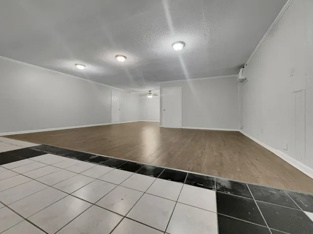a view of an empty room with wooden floor