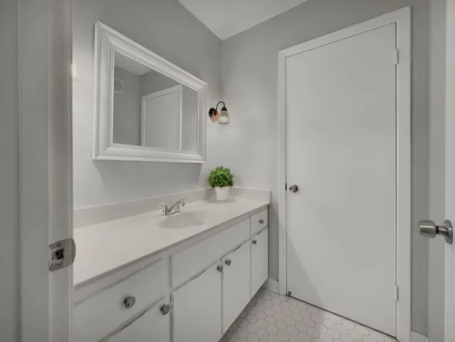an empty room with a chandelier fan and windows
