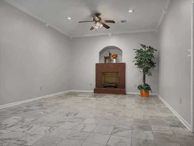 an empty room with a fireplace and potted plant