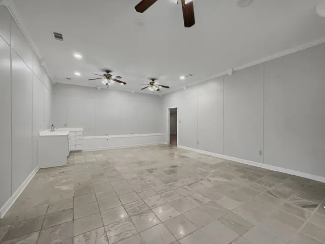 an empty room with a ceiling fan and bathroom