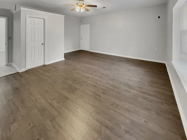 a view of an empty room with wooden floor