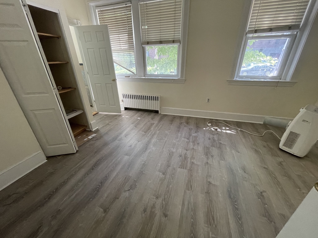 96 St Paul Street, Unit 2 Brookline, MA 02446 - Photo 8 of 14 a view of an empty room with wooden floor and a window