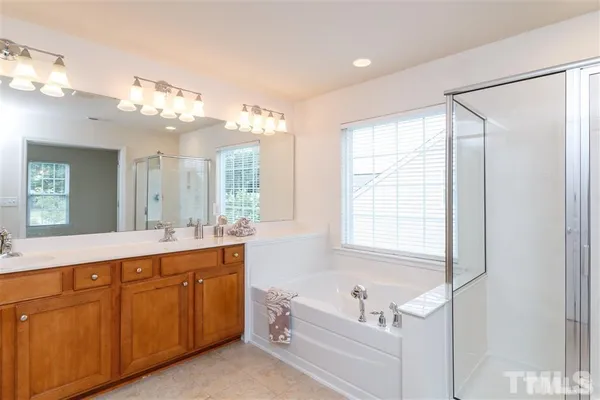 a bathroom with a tub sink and mirror