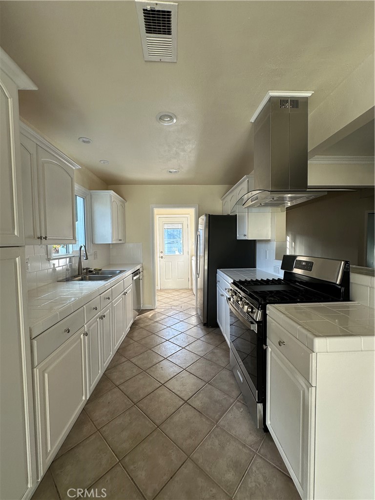 6447 Balcom Avenue Reseda, CA 91335 - Photo 18 of 49 a kitchen with stainless steel appliances a sink stove and cabinets