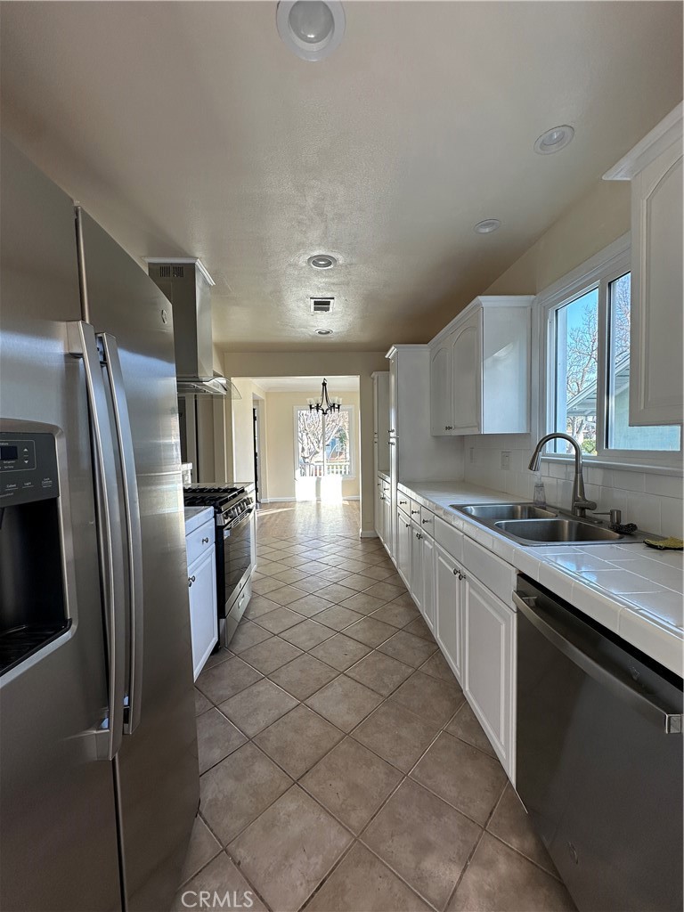 6447 Balcom Avenue Reseda, CA 91335 - Photo 19 of 49 a kitchen with stainless steel appliances granite countertop a refrigerator a sink a stove and white cabinets