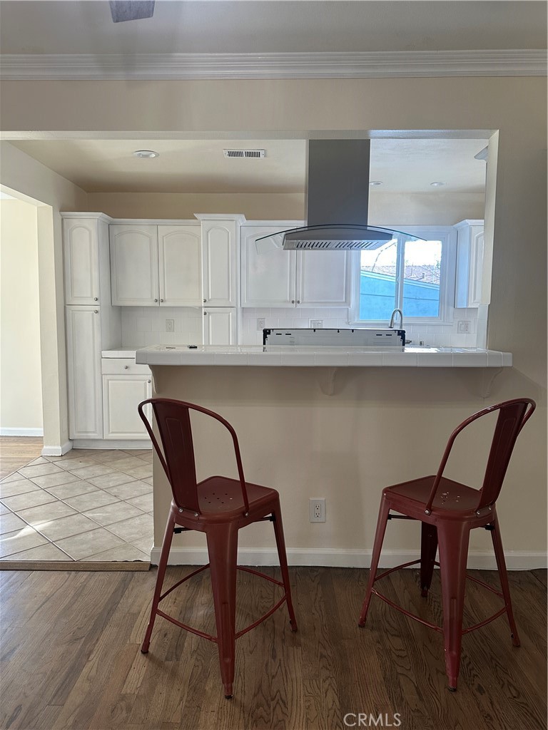 6447 Balcom Avenue Reseda, CA 91335 - Photo 25 of 49 a kitchen with a table chairs in it and wooden floors
