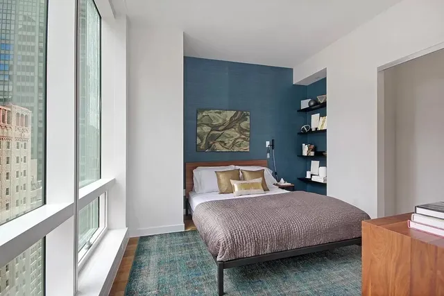 a bedroom with a bed and a large window with outer view