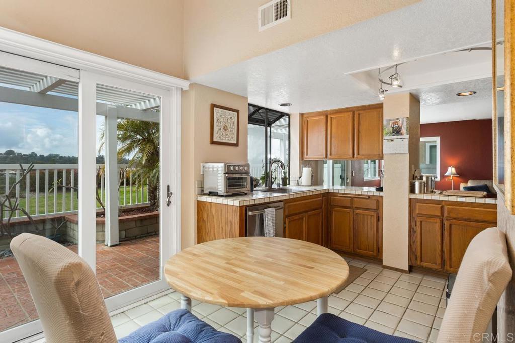1570 Pacific Ranch Drive Encinitas, CA 92024 - Photo 8 of 35 a kitchen with a refrigerator a stove dining table and chairs