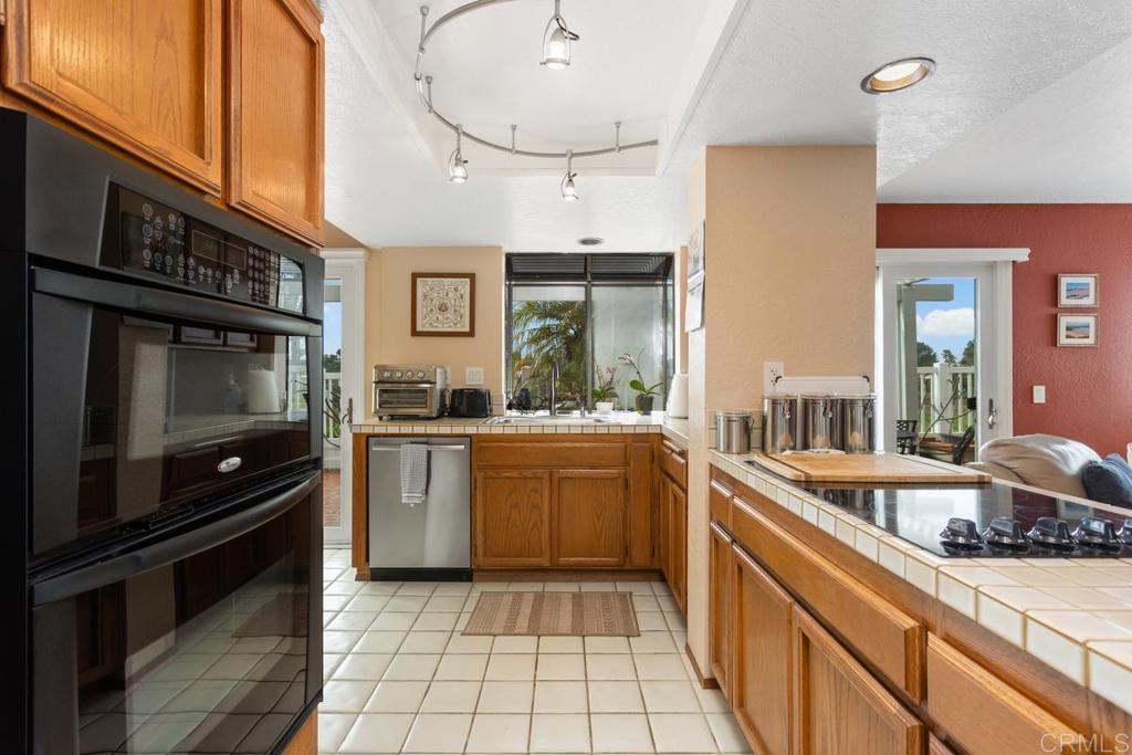 1570 Pacific Ranch Drive Encinitas, CA 92024 - Photo 10 of 35 a kitchen with stainless steel appliances a stove a sink and cabinets