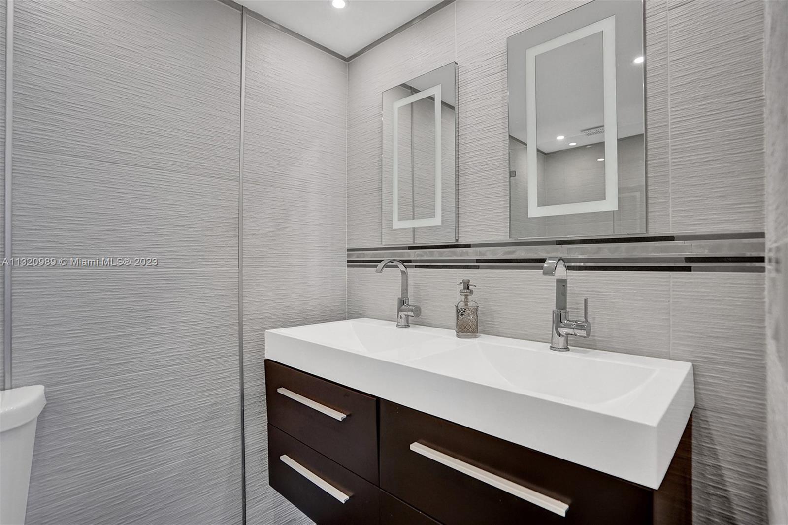 200 Southeast 15th Road, Unit 6I Miami, FL 33129 - Photo 16 of 50 a bathroom with a sink and a mirror