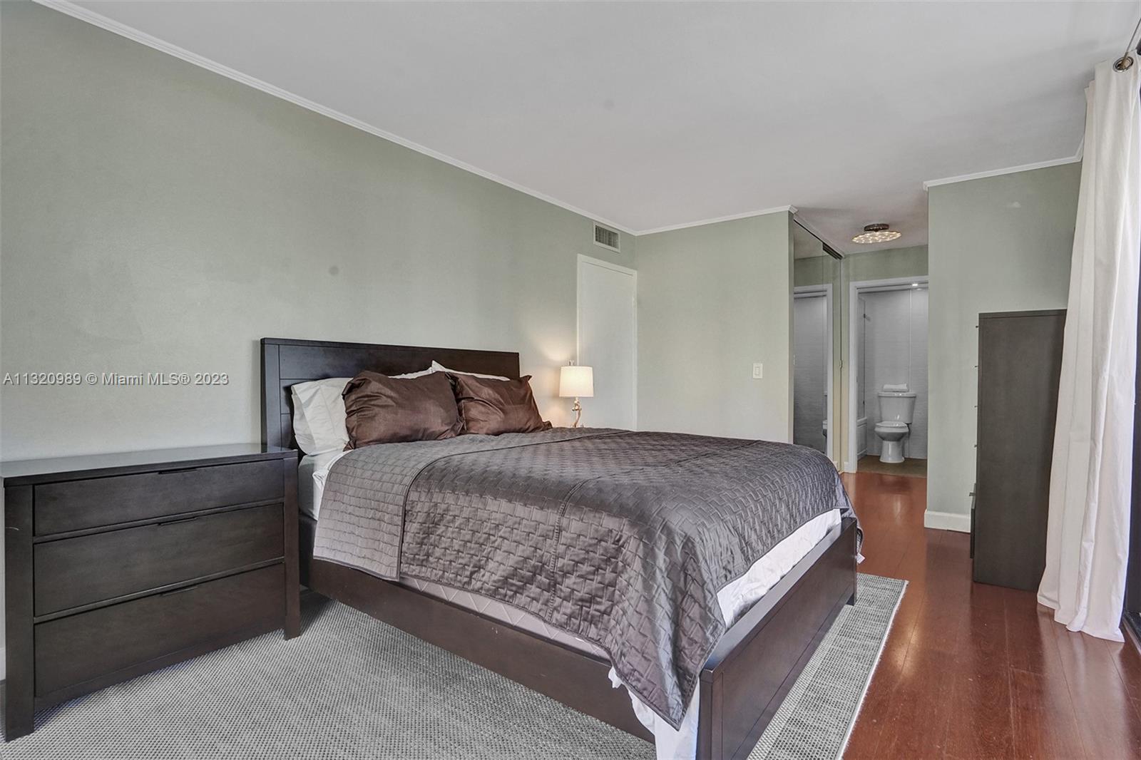 200 Southeast 15th Road, Unit 6I Miami, FL 33129 - Photo 19 of 50 a bedroom with a bed and wooden floor