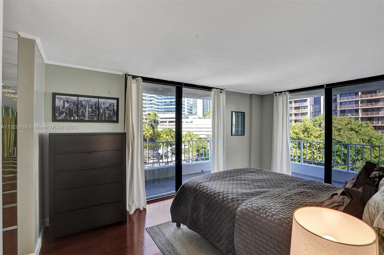 200 Southeast 15th Road, Unit 6I Miami, FL 33129 - Photo 20 of 50 a bedroom with a bed a dresser and a large window