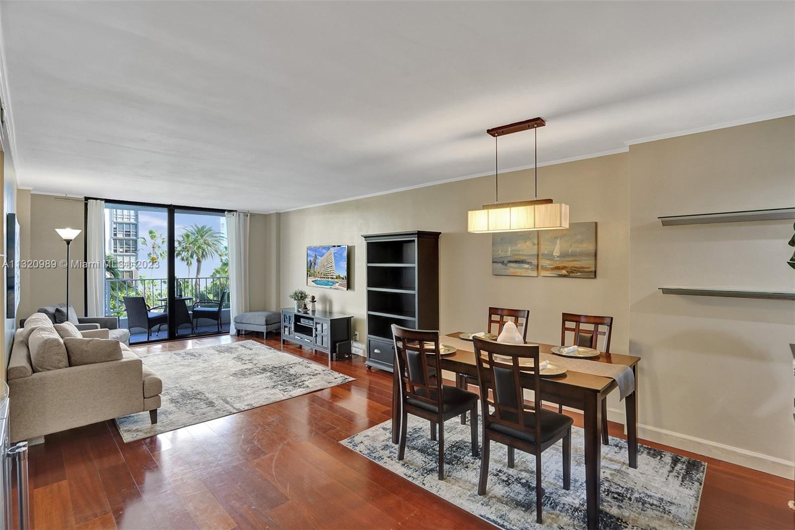 200 Southeast 15th Road, Unit 6I Miami, FL 33129 - Photo 3 of 50 a living room with furniture a flat screen tv and wooden floor