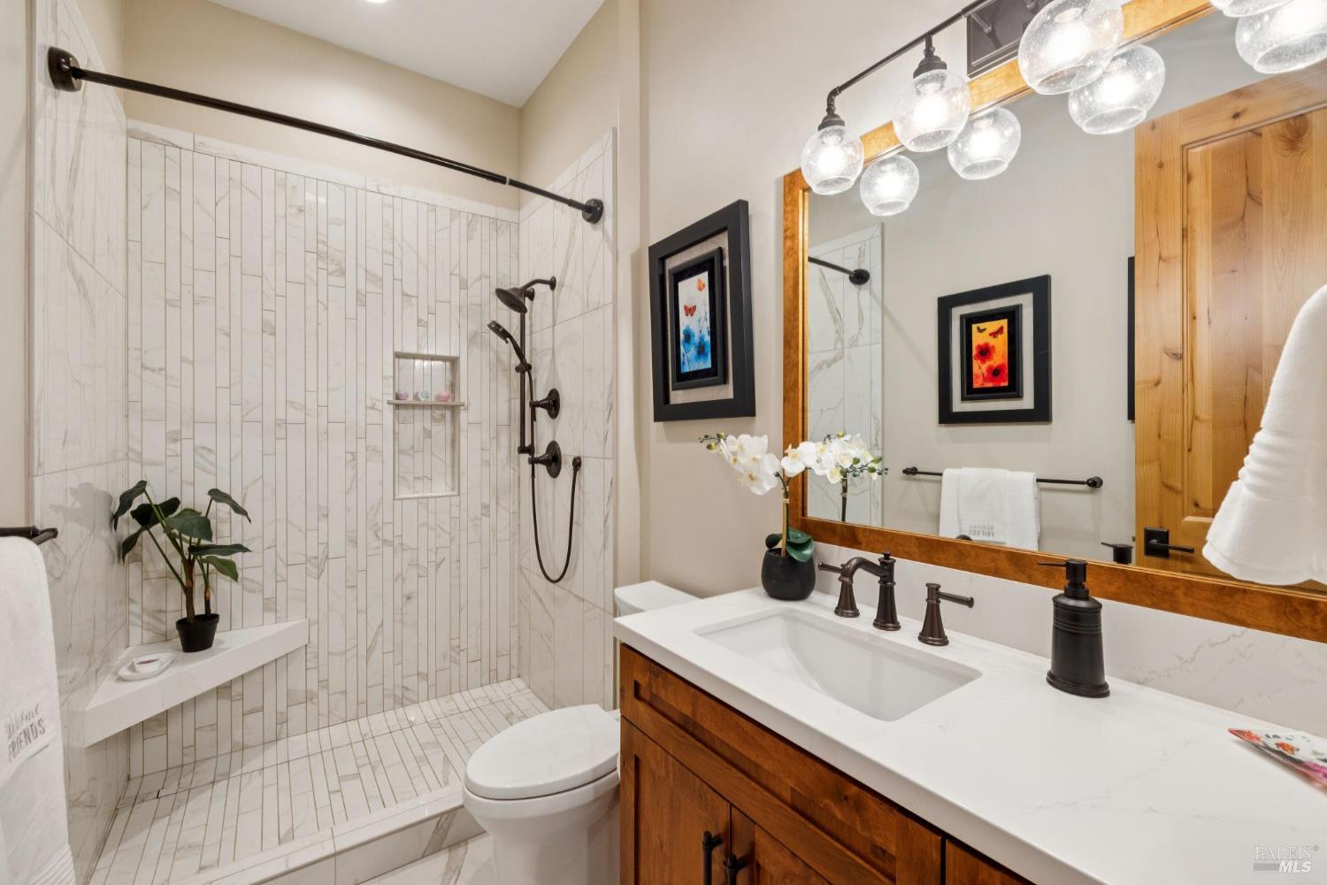 3882 Royal Manor Place Santa Rosa, CA 95404 - Photo 50 of 98 Main level full bathroom features quartz countertops and Moen oil bronzed fixtures. Step in shower includes dual shower heads and a linear drain.