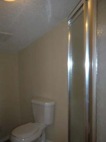 a white toilet sitting next to a shower