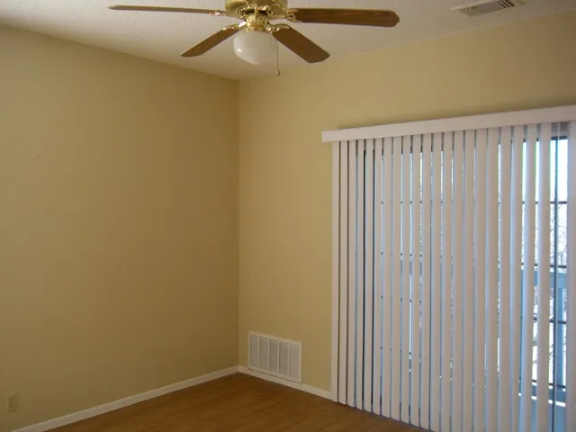 a view of a room with a window and a ceiling fan