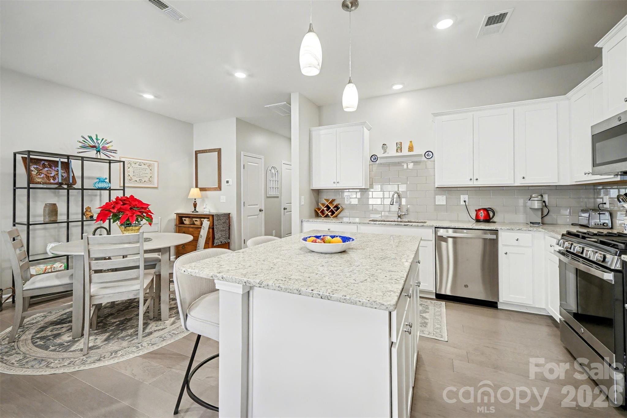 226 Quinn Road Matthews, NC 28104 - Photo 17 of 30 a kitchen that has a lot of white cabinets and stainless steel appliances