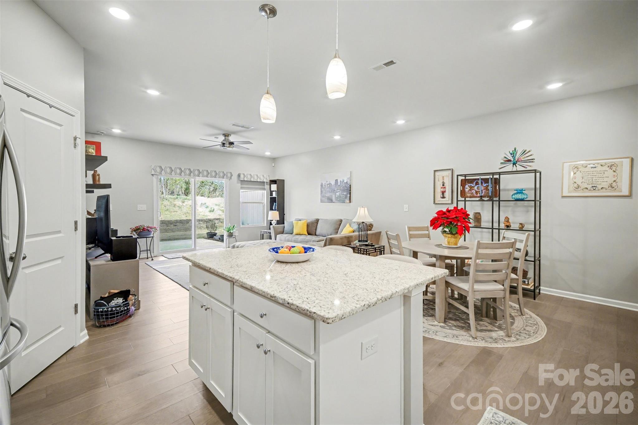 226 Quinn Road Matthews, NC 28104 - Photo 18 of 30 a view of kitchen island with stainless steel appliances granite countertop dining table chairs and white cabinets