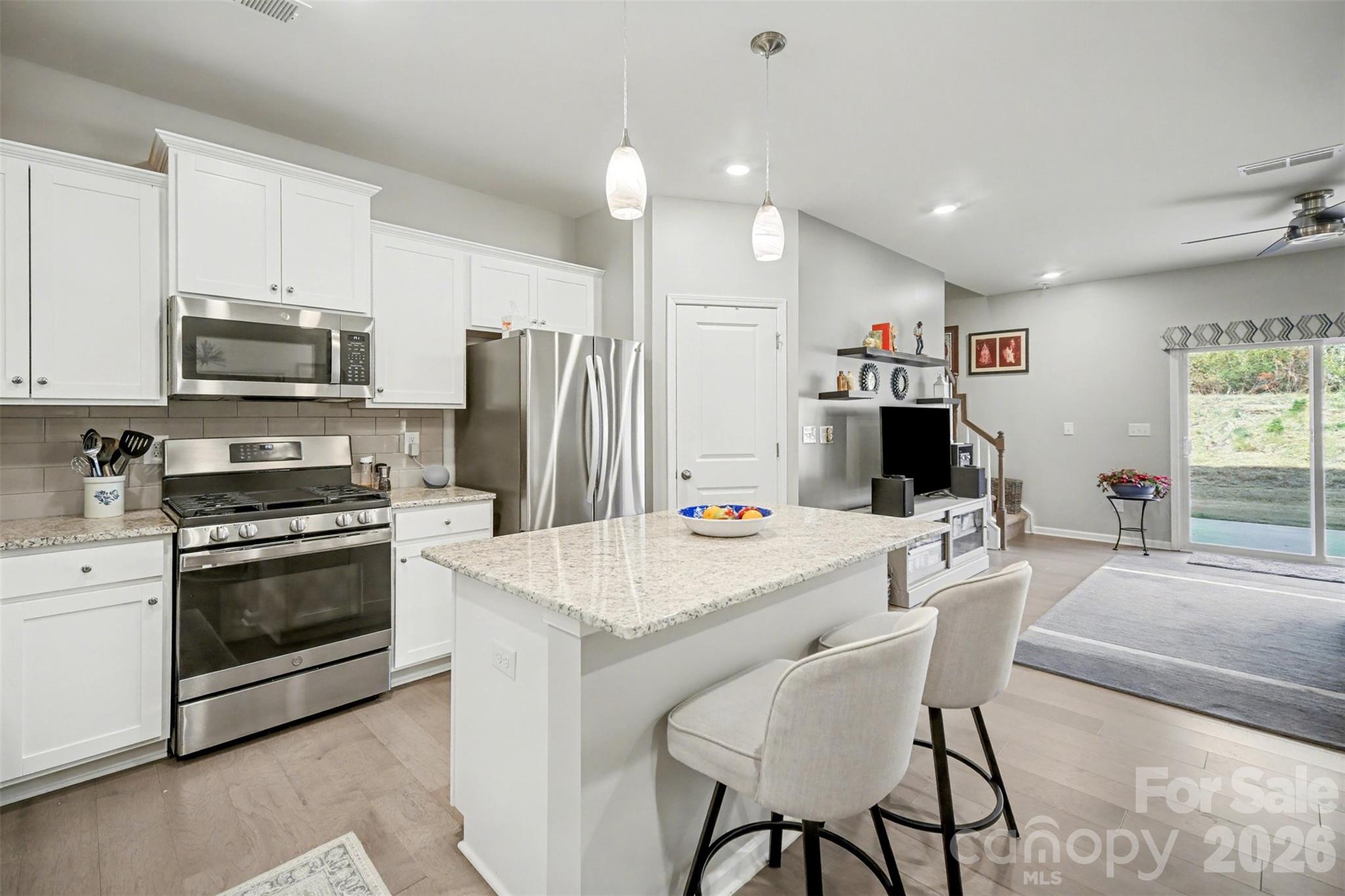 226 Quinn Road Matthews, NC 28104 - Photo 3 of 30 a kitchen with stainless steel appliances a stove a refrigerator a sink a stove a dining table and chairs