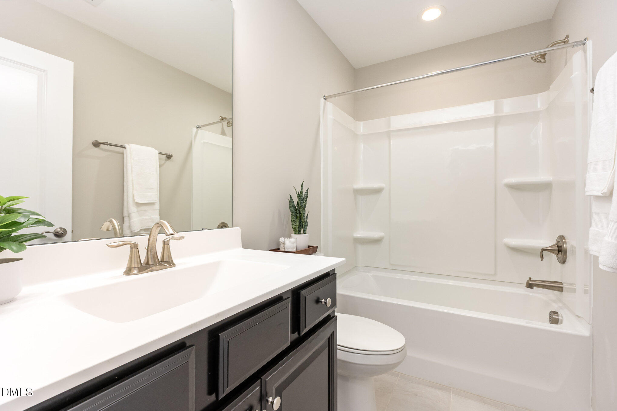 608 Atticus Way Durham, NC 27703 - Photo 17 of 30 a bathroom with a sink a toilet a mirror a bathtub and shower