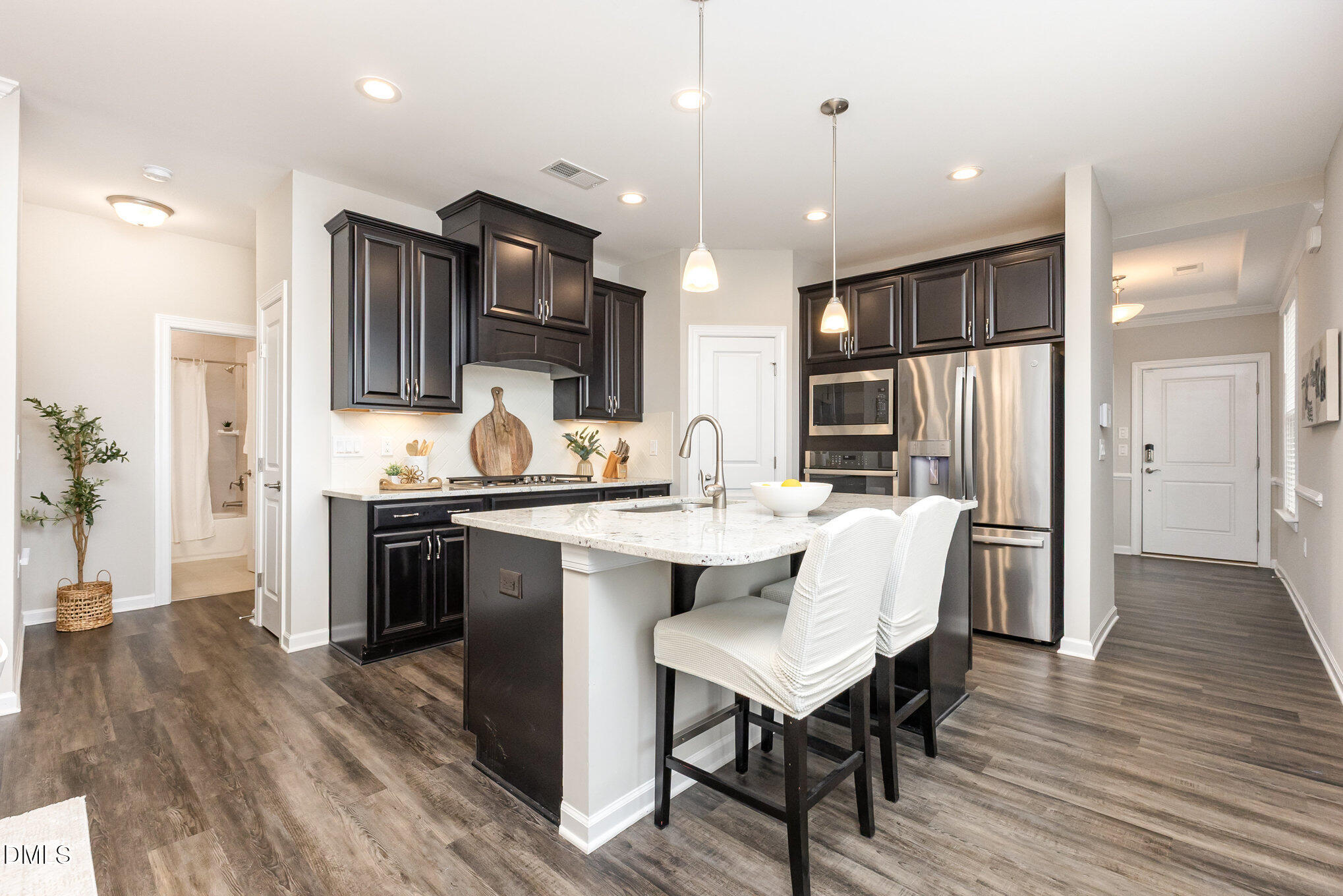 608 Atticus Way Durham, NC 27703 - Photo 2 of 30 a kitchen with stainless steel appliances kitchen island granite countertop a refrigerator a stove a sink a dining table and chairs with wooden floor