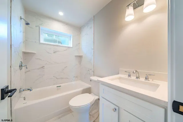 a bathroom with a sink mirror toilet and bathtub