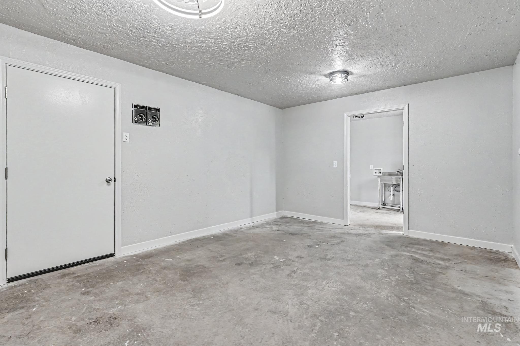 1023 State Street Weiser, ID 83672 - Photo 22 of 25 Spacious room with concrete flooring, light gray walls, and white trim